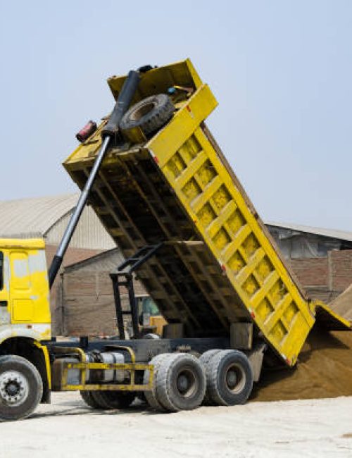 Ten yard dump truck delivering a load of dirt for a fill project at a new commercial development construction project